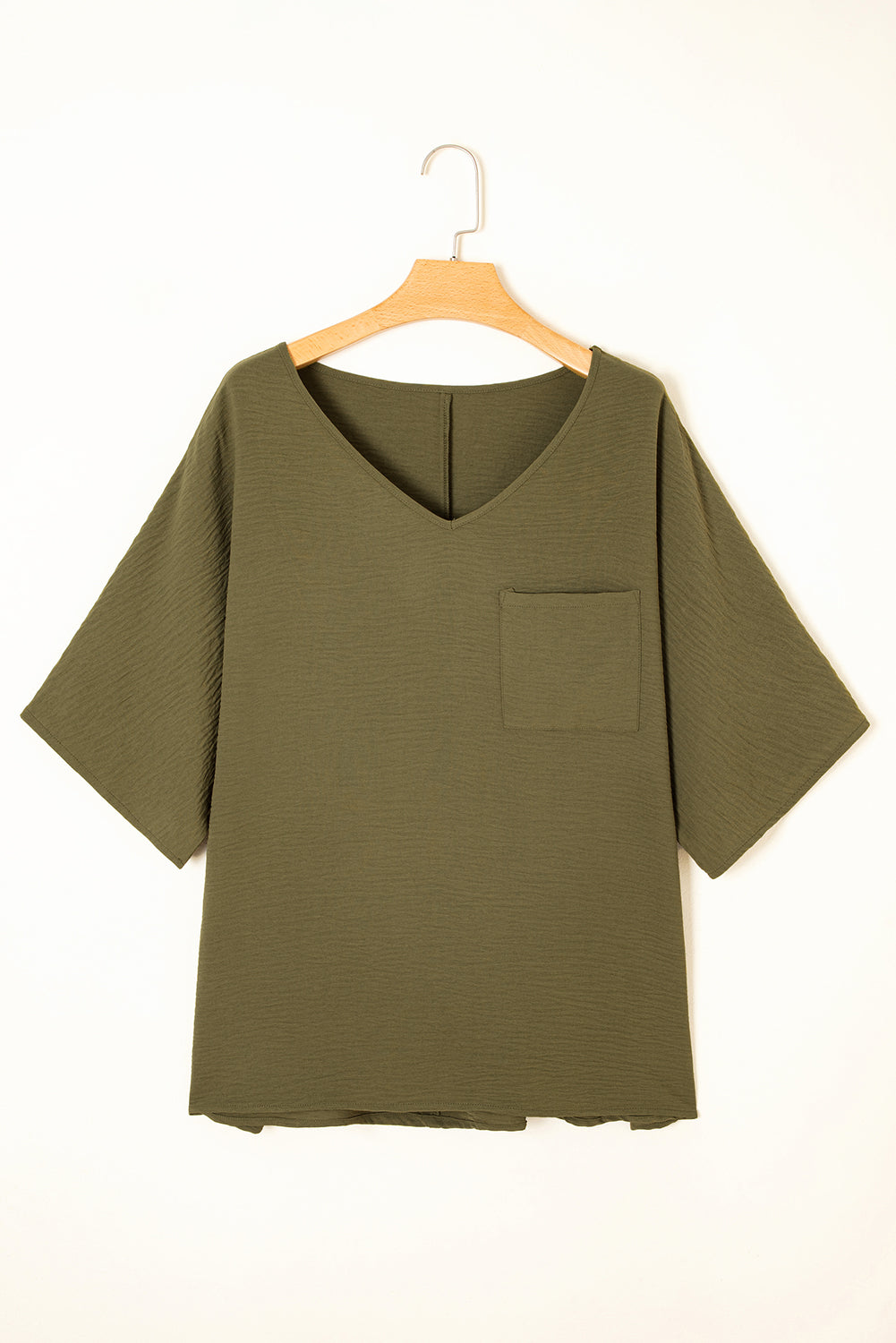 Green shirt on a hanger against a white background