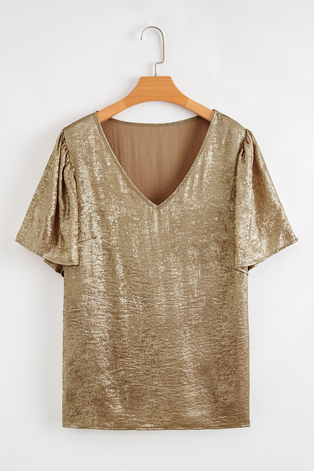 Gold metallic top on a wooden hanger against a white background